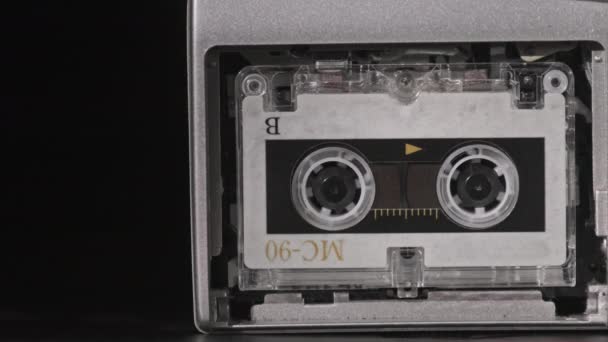 Cinta de audio vintage con una etiqueta en blanco girando en la grabadora de cassette, primer plano — Vídeo de stock