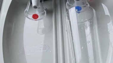 Su soğutucu, temiz su bardaktan bardağa akıyor.