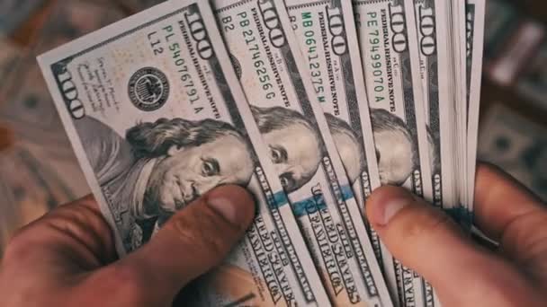 Dólares em mãos masculinas no fundo da tabela com dinheiro, contando notas — Vídeo de Stock