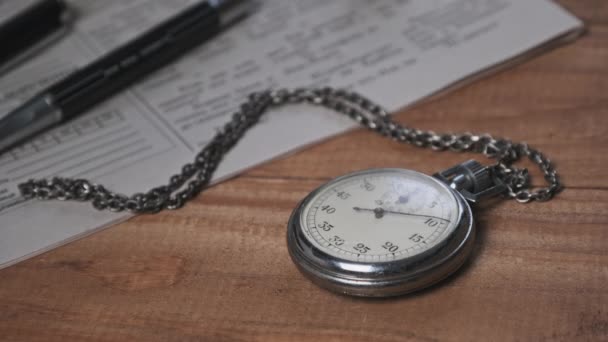 Vintage Stopwatch Lies on Wooden Desk with Old Documents and Counts Seconds — Stock Video