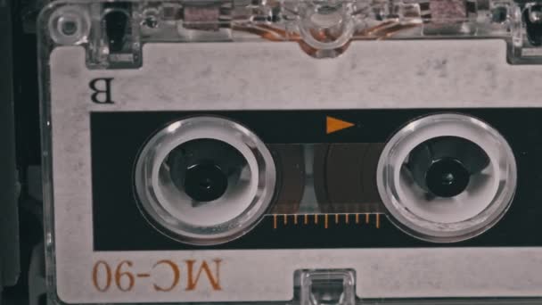 Cinta de audio vintage con una etiqueta en blanco girando en la grabadora de cassette, primer plano — Vídeos de Stock