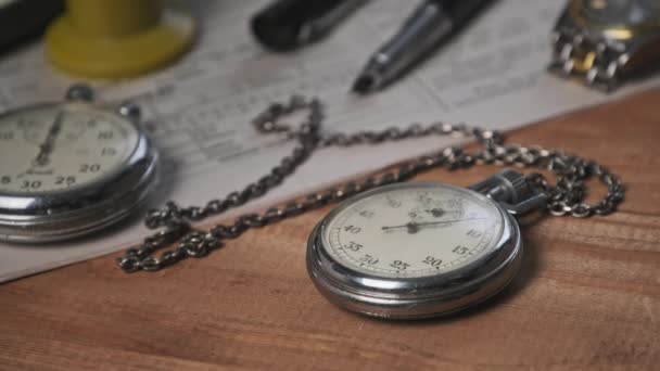 Chronomètre Vintage repose sur un bureau en bois avec de vieux documents et compte secondes — Video