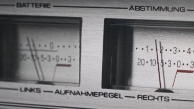 Gümüş renkli teyp kaydedicisinde iki analog VU ölçer, ok göstergeleri