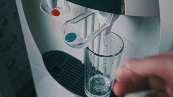 水冷器，清澈的水从饮水机中倒入玻璃杯 — 图库视频影像