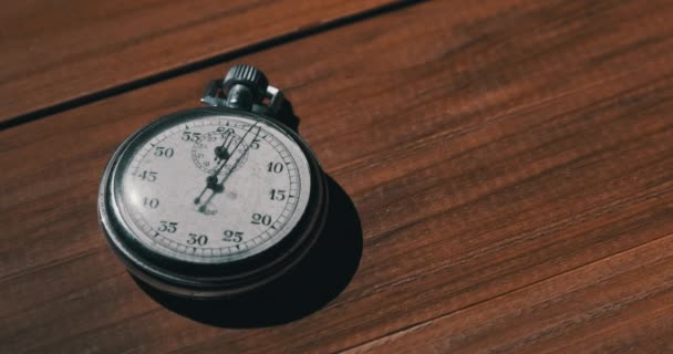 Oude vintage stopwatch ligt op houten tafel en telt de seconden — Stockvideo