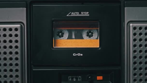 Casete de audio amarillo vintage tocando en la cubierta de una vieja grabadora de cinta — Vídeo de stock
