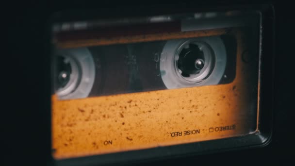 Casete de audio amarillo vintage tocando en la cubierta de una vieja grabadora de cinta — Vídeo de stock