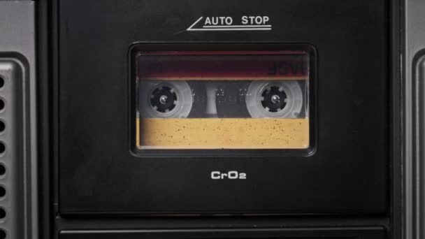 Fita cassete de áudio amarela vintage gira no convés de um gravador de fita antigo — Vídeo de Stock