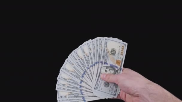 Mano masculina sosteniendo un ventilador de un montón de billetes de 100 dólares con canal alfa — Vídeo de stock