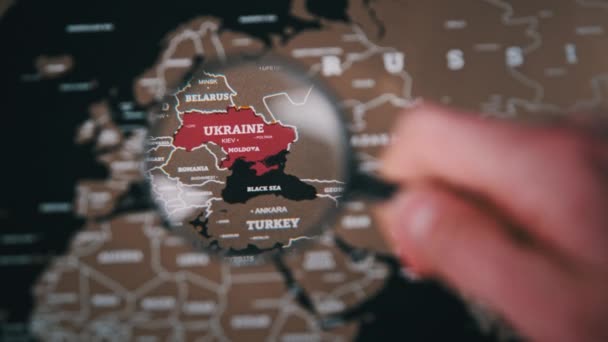 Ucrânia no mapa mundial sob uma lupa lupa, atenção mundial à guerra — Vídeo de Stock