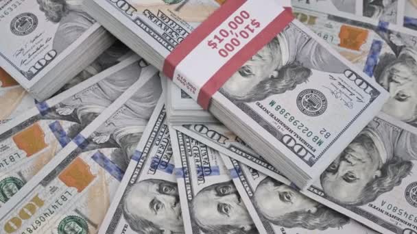 I pacchetti di dollari ruotano su un mucchio di soldi, pile di 10000 banconote americane — Video Stock
