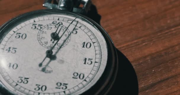 Oude vintage stopwatch ligt op houten tafel en telt de seconden — Stockvideo