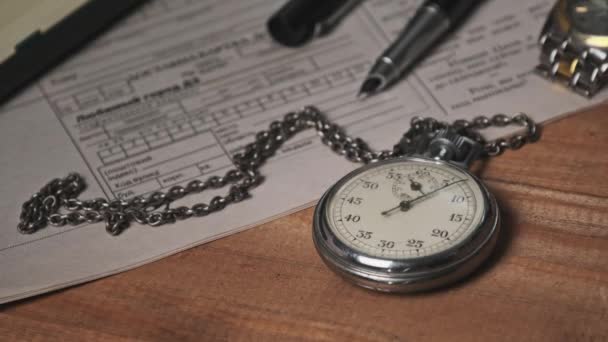 Vintage Stopwatch Lies on Wooden Desk with Old Documents and Counts Seconds (engelsk). – stockvideo