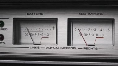Gümüş renkli teyp kaydedicisinde iki analog VU ölçer, ok göstergeleri