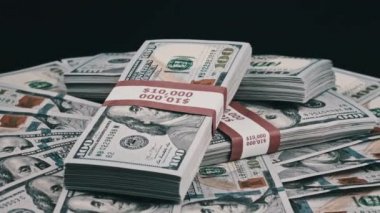 Para Yığını Üzerinde Yatan ve Siyah Arkaplanda Dönen Dolar Paketleri
