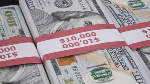Três pilhas de 10000 dólares americanos As notas em pacotes bancários são giratórias — Vídeo de Stock