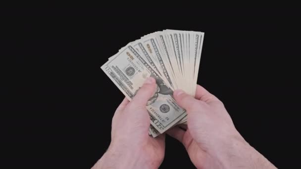 Manos masculinas sosteniendo un ventilador de un montón de proyectos de ley de 20 dólares con canal alfa — Vídeo de stock