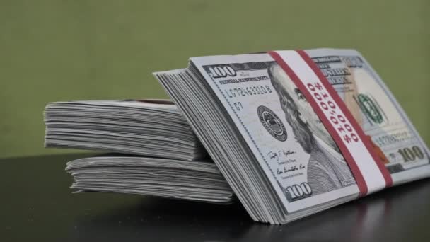 Пачки долларов вращаются на зеленом фоне, куча денег — стоковое видео