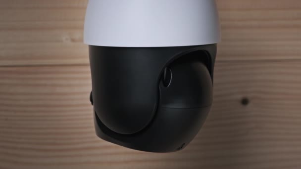 Vigilancia de la cámara de seguridad gira sobre fondo de madera — Vídeos de Stock