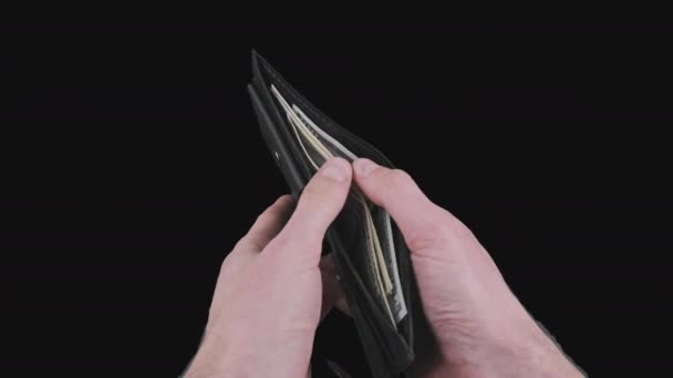 Τα αρσενικά χέρια δείχνουν ένα μαύρο πορτοφόλι με μερικούς λογαριασμούς δολαρίου στο κανάλι Alpha — Αρχείο Βίντεο
