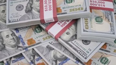 Dolar desteleri yığınla para üzerinde dönüyor, yığınla 10000 Amerikan banknotları.