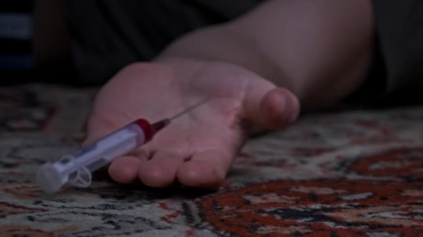 Υπερδοσολογία, Addicts χέρι πέφτει στο πάτωμα, Σύριγγα ναρκωτικών πέφτει έξω από αυτό — Αρχείο Βίντεο
