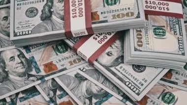 Dolar desteleri yığınla para üzerinde dönüyor, yığınla 10000 Amerikan banknotları.