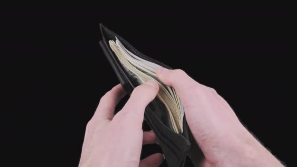 Mannlige hender viser en svart lommebok full av 100 dollar på Alfa-kanalen. – stockvideo