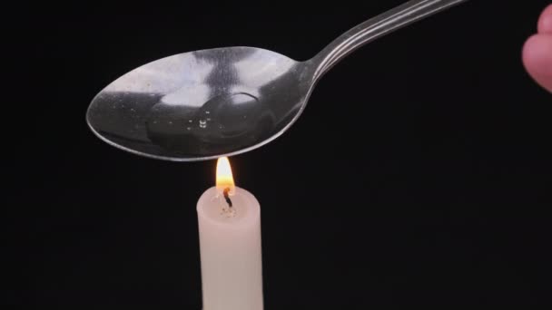 Cooking Drugs in a Spoon on a Candle Flame — стоковое видео