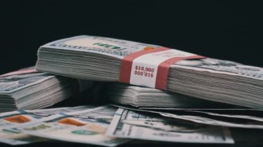Para Yığını Üzerinde Yatan ve Siyah Arkaplanda Dönen Dolar Paketleri