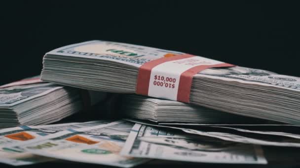Bundles of Dollars Lying on a Pile of Money and Rotate on Black Background — Stock Video