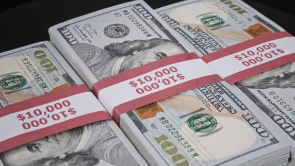 Três pilhas de 10000 dólares americanos As notas em pacotes bancários são giratórias — Vídeo de Stock
