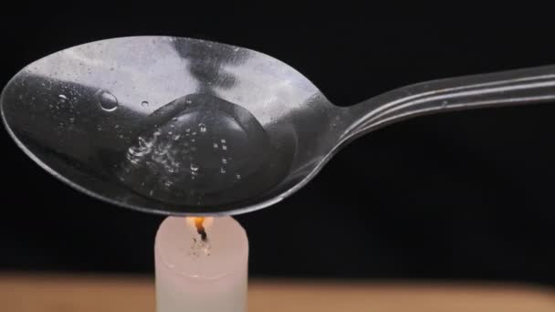 Cucinare droga in un cucchiaio su una fiamma di candela — Video Stock