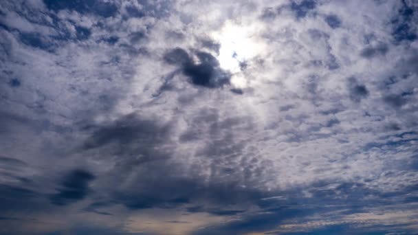 Gelaagde wolken bewegen in de blauwe lucht onder heldere zon, pluizig wolkendek Timelapse — Stockvideo