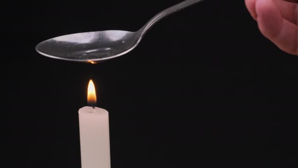 Matlagning droger i en sked på en ljuslåga — Stockvideo