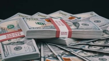 Para Yığını Üzerinde Yatan ve Siyah Arkaplanda Dönen Dolar Paketleri