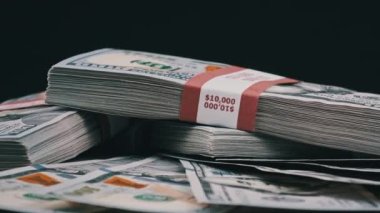 Para Yığını Üzerinde Yatan ve Siyah Arkaplanda Dönen Dolar Paketleri