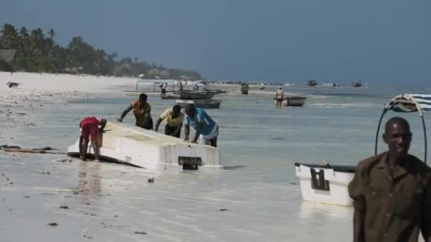 Bir Afrikalı Balıkçı Zanzibar, Low Tide 'da Algae' den bir tekne temizliyor. — Stok video