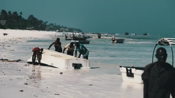 Bir Afrikalı Balıkçı Zanzibar, Low Tide 'da Algae' den bir tekne temizliyor. — Stok video