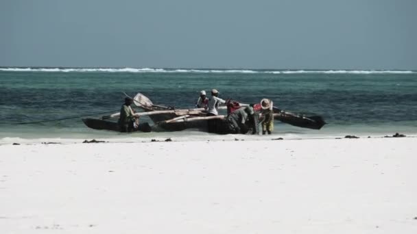 Gruppe afrikanischer Fischer in traditionellem Holzboot in Strandnähe, Sansibar — Stockvideo