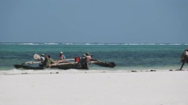 Bir grup Afrikalı Balıkçı Plaj yakınlarındaki geleneksel ahşap botta, Zanzibar