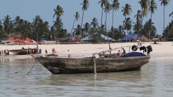 Hagyományos afrikai halászhajó rekedt homokos tengerparton apálykor, Zanzibár — Stock videók