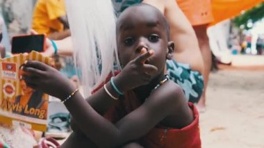 Yerli Brezilyalı Açlıktan ölen Afrikalı Çocuk Kamera ve El sallayan Eller 'e bakıyor, Zanzibar