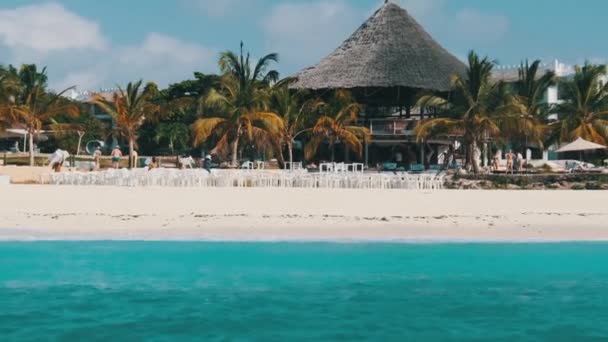 Zanzibar tengerpart Sandy Beach, Palms, és szállodák. Kilátás a lebegő hajóról — Stock videók