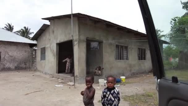 Afrikanischer Junge winkt in einem armen Dorf in der Nähe von Slum, Sansibar, Afrika — Stockvideo