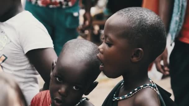 Lokale hongerige Afrikaanse kleine kinderen lopen op straat onder de mensen, Zanzibar — Stockvideo
