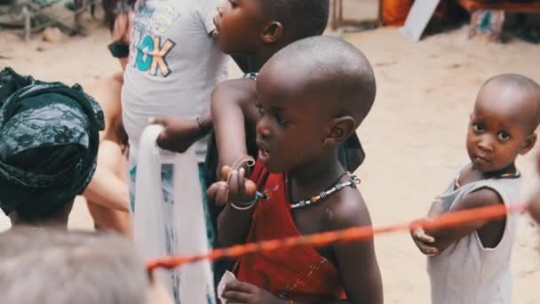 Místní africké hladové dítě jí papír na ulici mezi lidmi, Zanzibar, Afrika — Stock video
