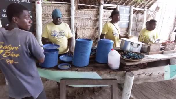 Afrykanie przygotowują grillowane owoce morza dla turystów przybywających na rajską wyspę, Zanzibar — Wideo stockowe