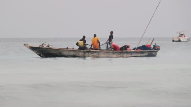 Pescadores africanos em peixes de barco de madeira no oceano usando uma rede de pesca, Zanzibar — Vídeo de Stock