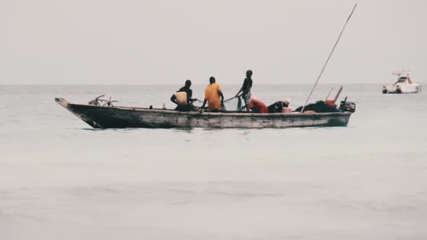 Afrikanska fiskare på trä båt fisk i havet med hjälp av ett fiskenät, Zanzibar — Stockvideo